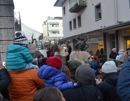 Grupo de personas esperando el inicio del desfile de Krampus en Pergine (Italia)